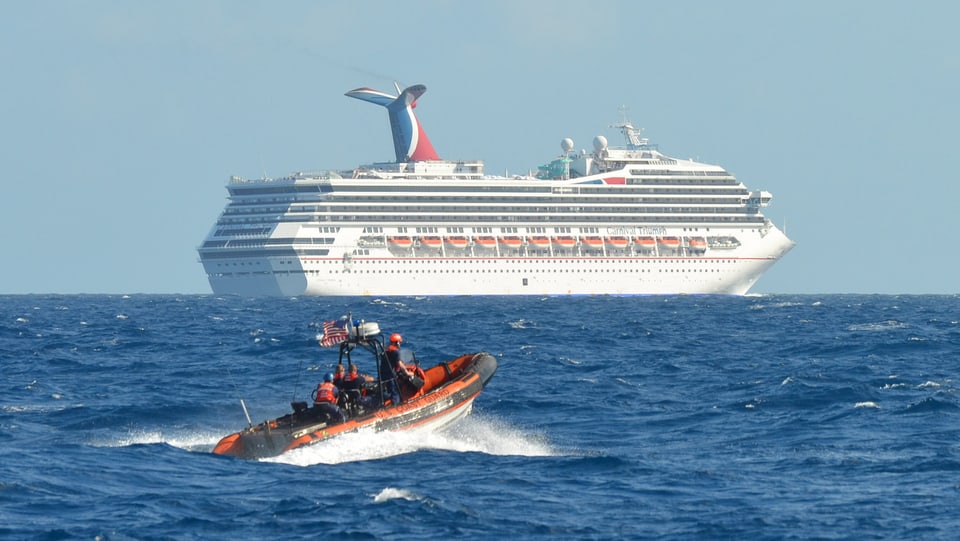 Kreuzfahrtschiff auf dem Meer, davor ein kleines Boot.