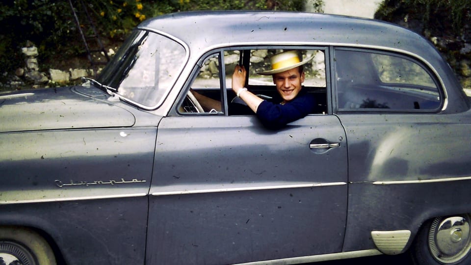 Ein Mann schaut aus dem Fenster eines alten Autos.