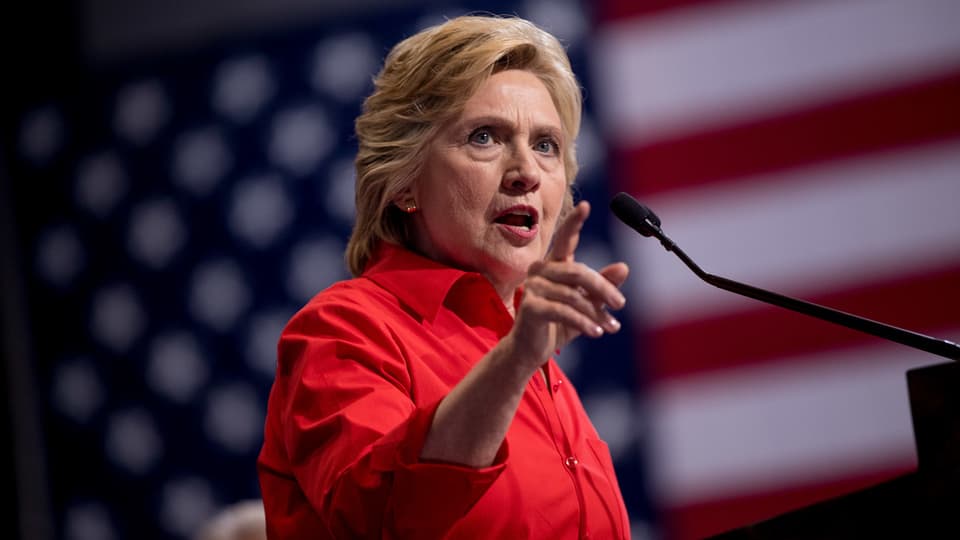 Hillary Clinton spricht ins Mikrofon und zeigt dabei mit dem Finger. 