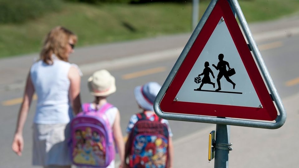 Kinder und ihre Mutter auf dem Schulweg.