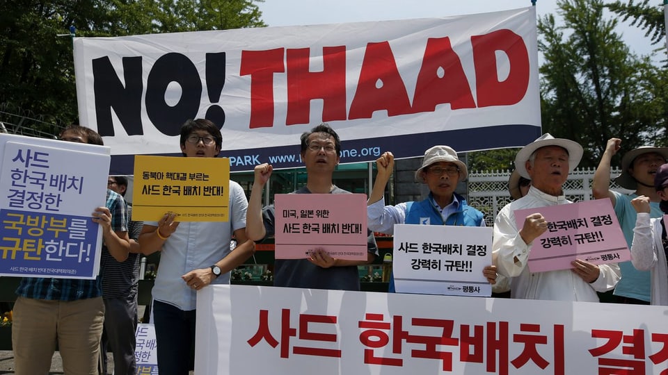 Südkoreanische Demonstranten halten Transparente auf.
