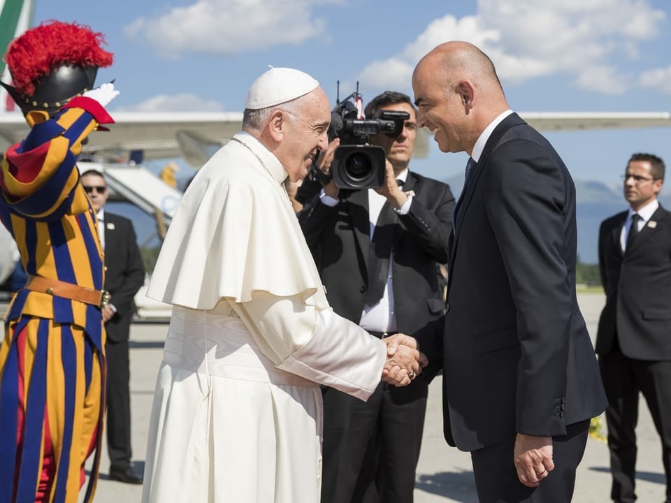 Papst Franziskus schüttelt die Hand von Bundesrat Alain Berset auf dem Vorfeld des Flughafens Genf