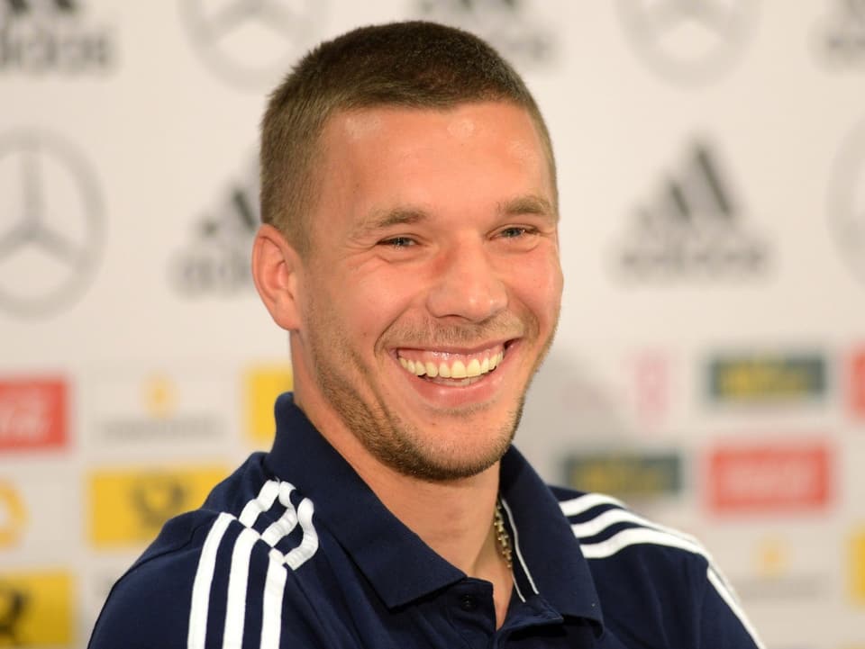 Lukas Podolski strahlt über das ganze Gesicht. 