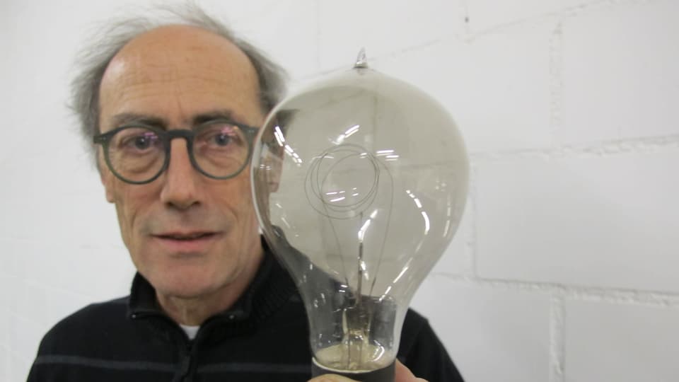 Denkmalpfleger Peter Baumgartner mit einer Kohlefaden-Glühbirne.