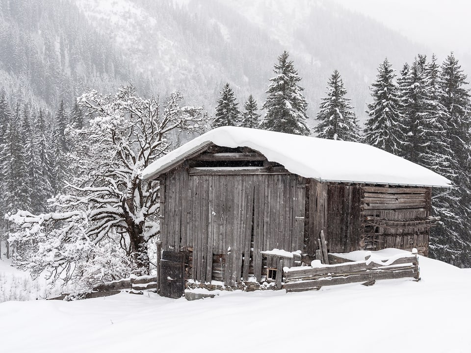 Das Bild zeigt eine Hütte im Schnee