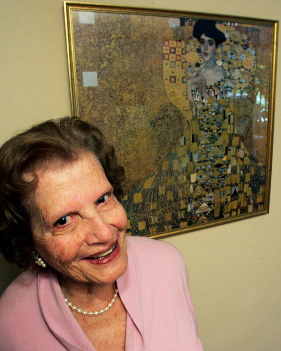 Maria Altmann posiert vor der goldenen Adele von Gustav Klimt.