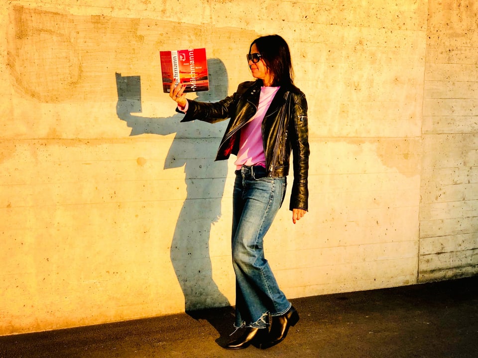Annette König liest im Gehen und hält dabei den Roman «Milchmann» von Anna Burns in der Hand