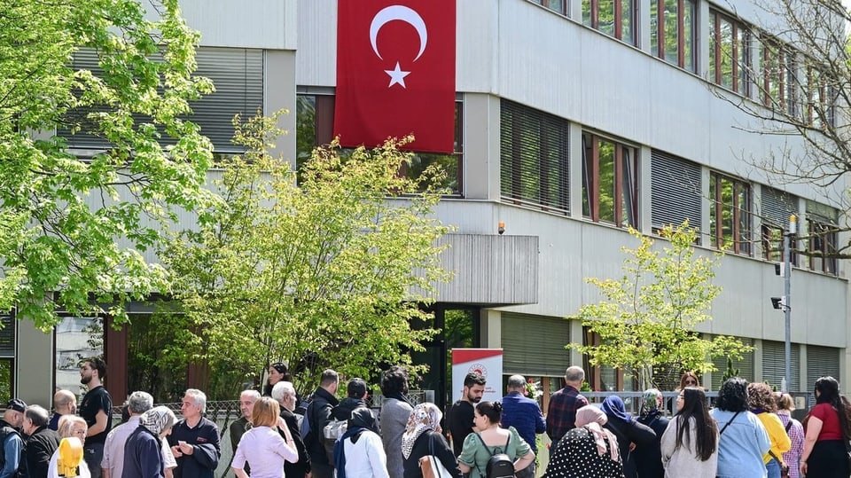 Türkinnen und Türken stehen vor einem Wahllokal in Stuttgart in einer langen Schlange.