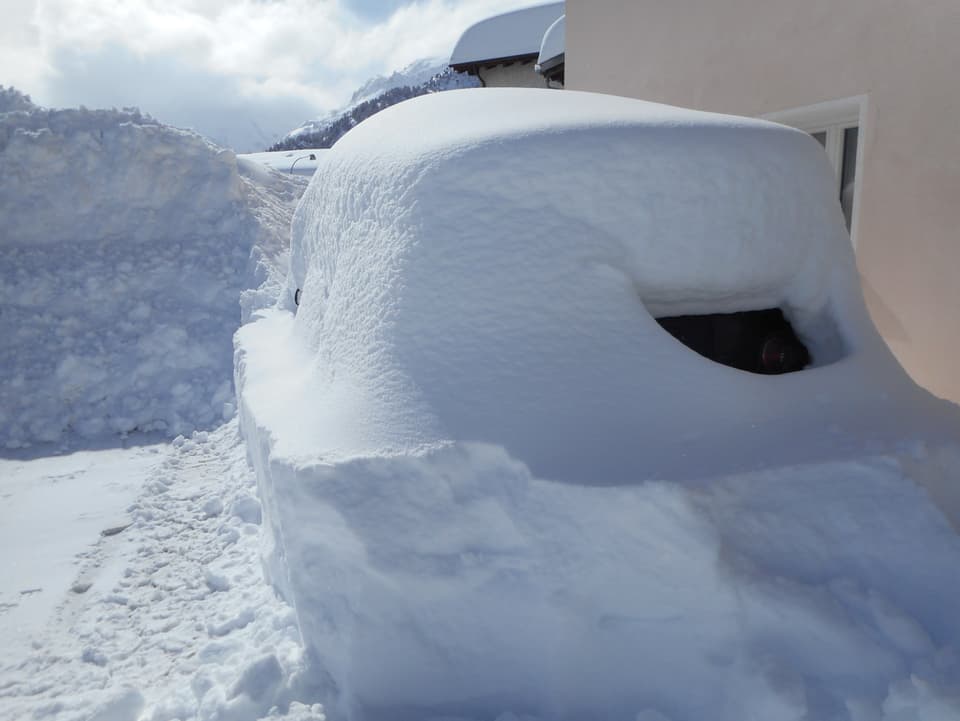 Ein Auto ist vor lauter Schnee kaum mehr zu erkennen.