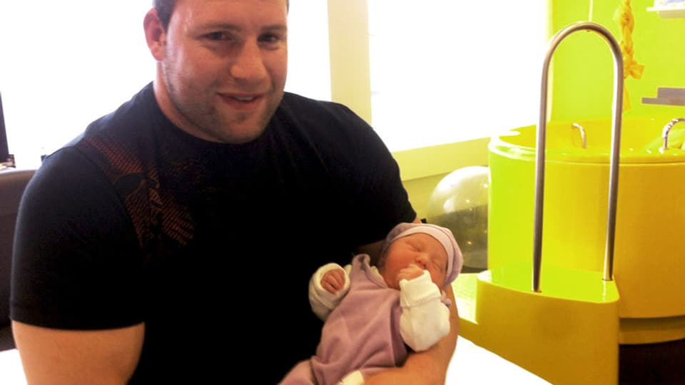 Adi Laimbacher mit einem Baby im Arm.
