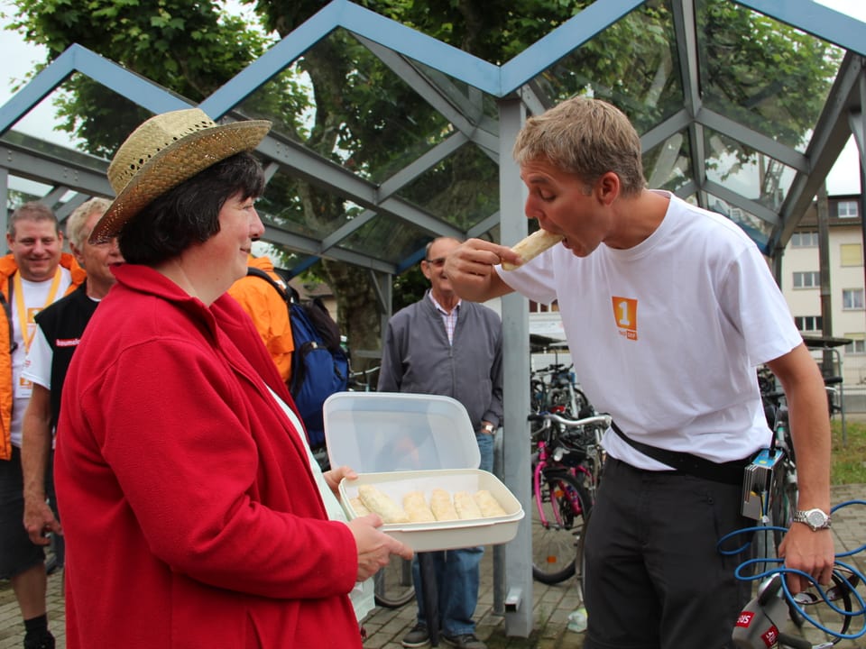 Mitwanderin überbringt Reto Scherrer in einem Gefäss frisch gebackene Nussgipfel.