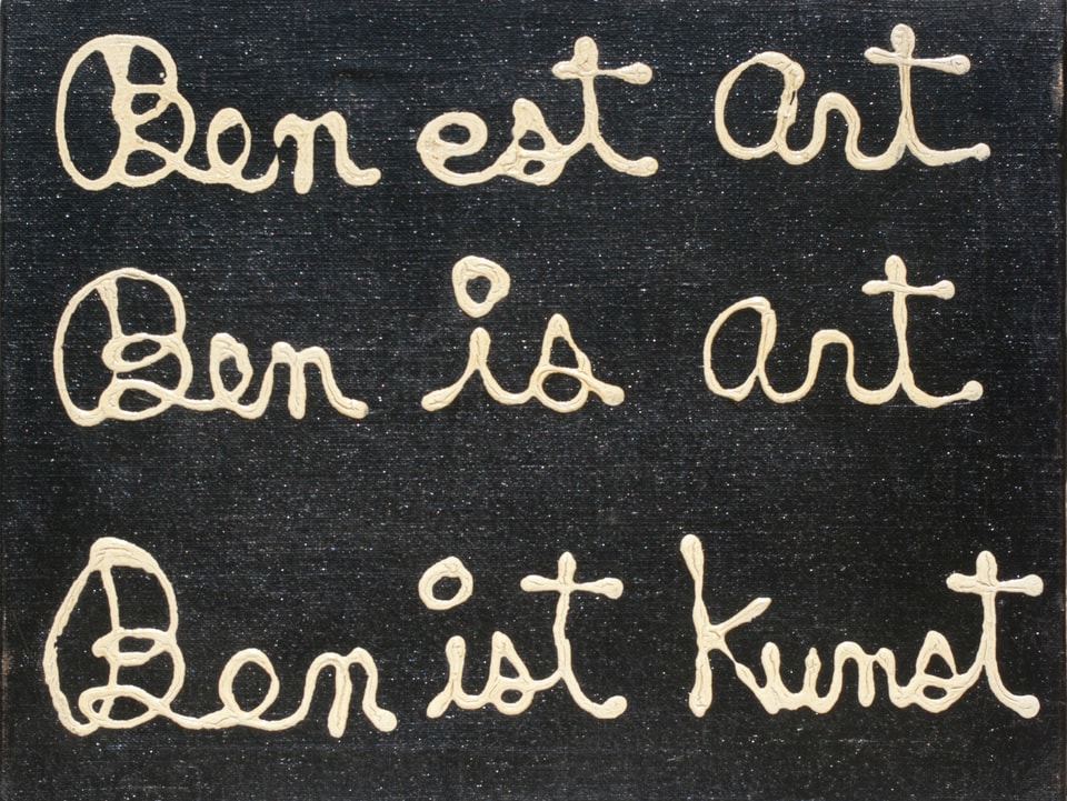 Weiss Schrift auf schwarzem Hintergrund: «Ben est art, Ben is art, Ben ist Kunst»
