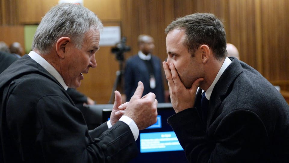 Oscar Pistorius (rechts) bespricht sich mit seinem Verteidiger Barry Roux (links).