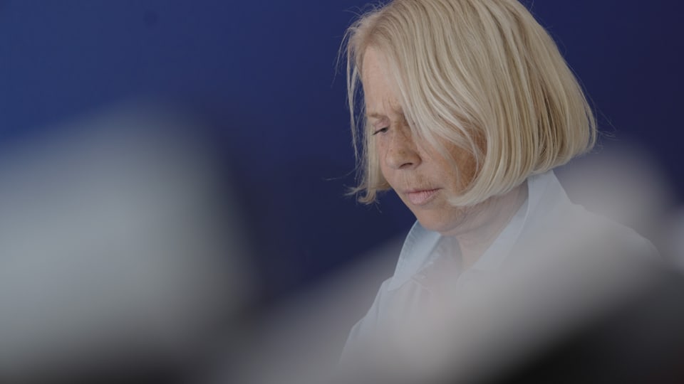 Blonde Frau mit geschlossenen Augen vor blauem Hintergrund
