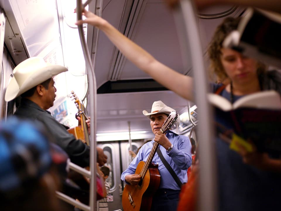 Zwei Männer mit Cowboyhut musizieren in der U-Bahn.