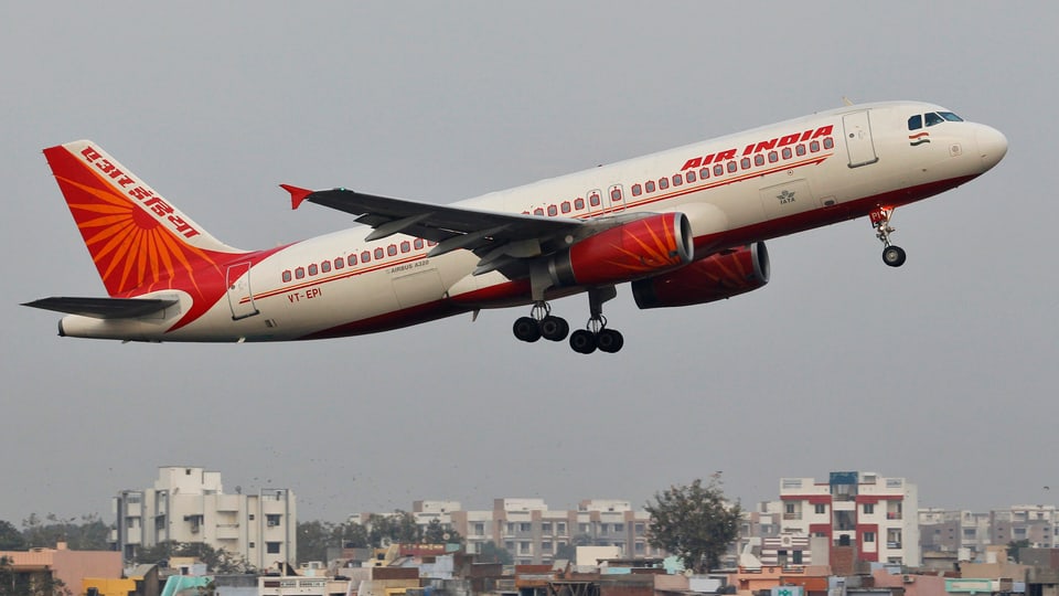 Ein Flugzeug der Air India fliegt tief über einer Stadt
