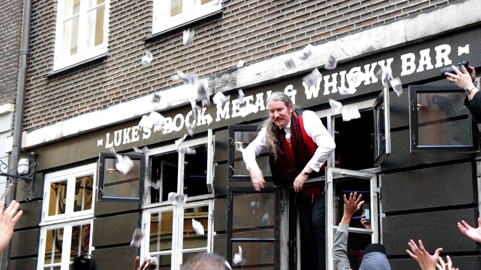 Mann wirft Geld aus Fenster, aus einer Bar in Kopenhagen Altstadt