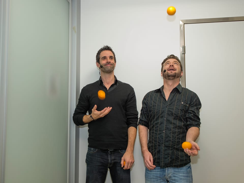 Philippe Gerber und Jann Hoffmann jonglieren mit drei Orangen.