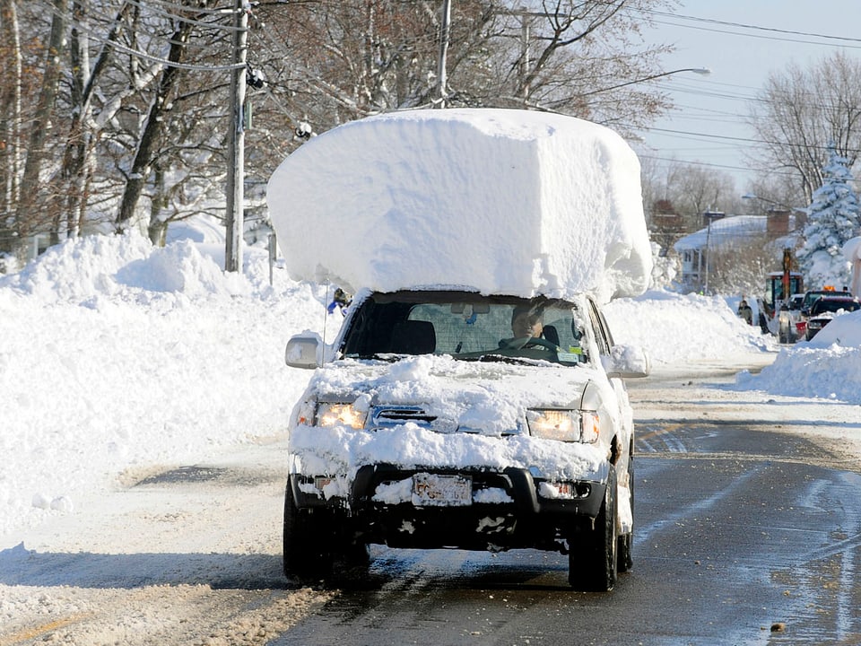 Auto mit viel Schnee auf dem Dach