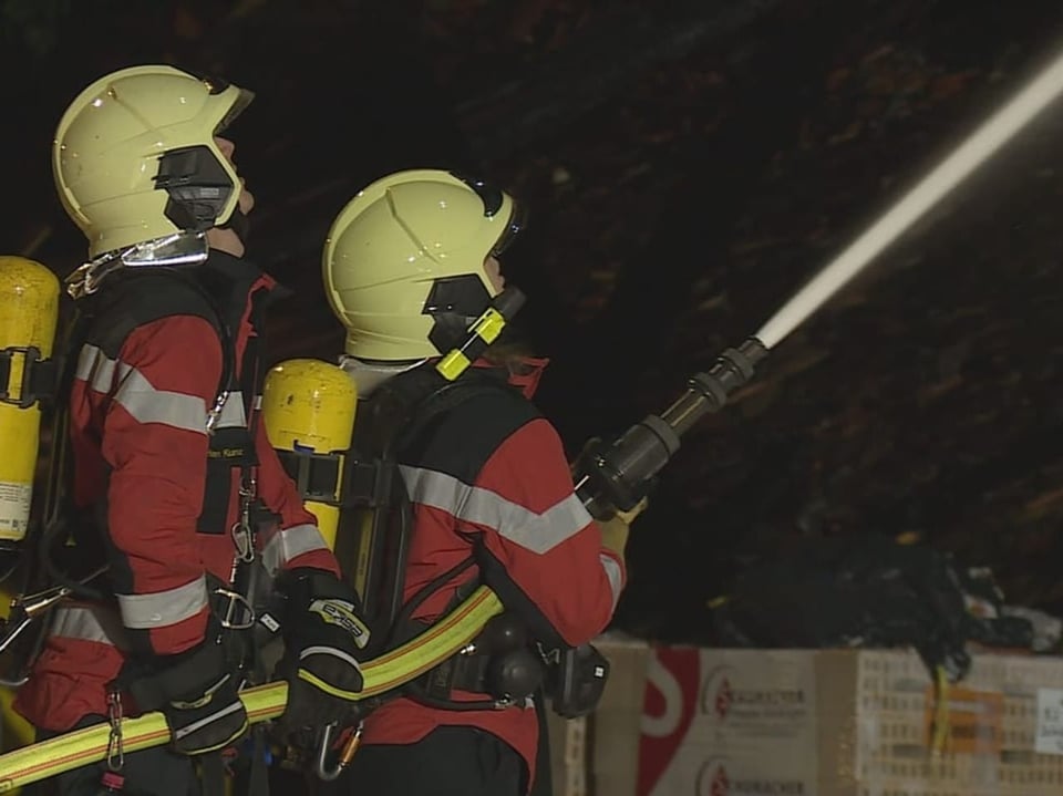 Corpo de bombeiros com canhões de água em ação.