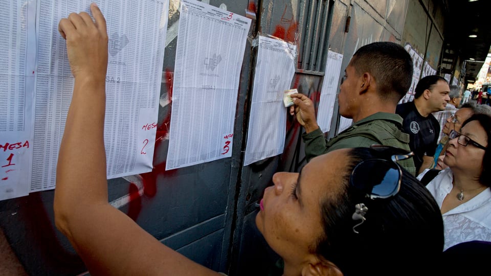 Vor einem Wahllokal in Caracas suchen Bewohner nach ihren Namen auf den Wahllisten. 