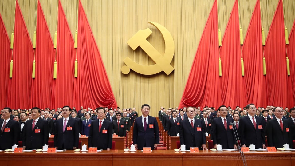 Frontal view of Chinese Communist Party members.  In the background: hammer and sickle
