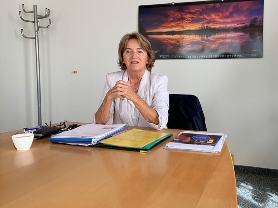 Renate Gautschy sitzt in ihrem Büro an einem Holztisch. Vor Ohr liegen Akten. Sie verschränkt die Arme.