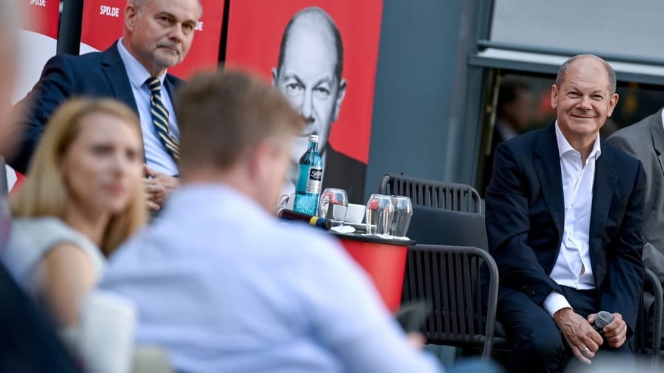 Scholz sitzt in einer Runde mit Unternehmerinnen und Unternehmern.