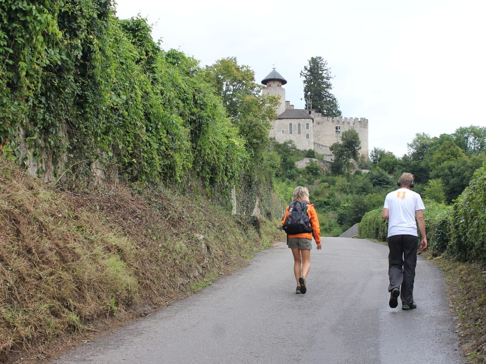 Reto Scherrer und Ladina Spiess auf der Strasse, im Hintergrund ein Schloss.