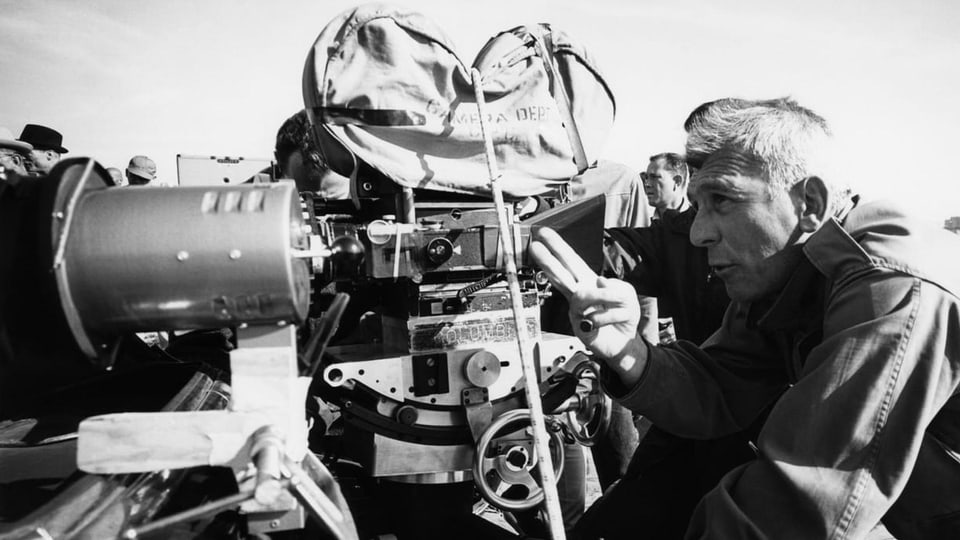 Regisseur Richard Brooks, im Profil, steht hinter einer Kamera.