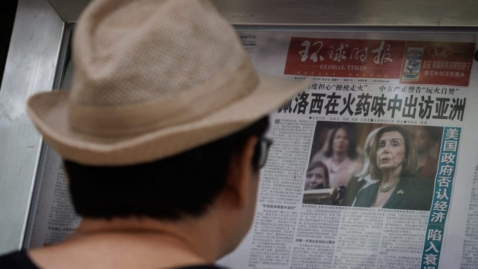 Mann liest chinesische Zeitung mit Pelosi-Foto