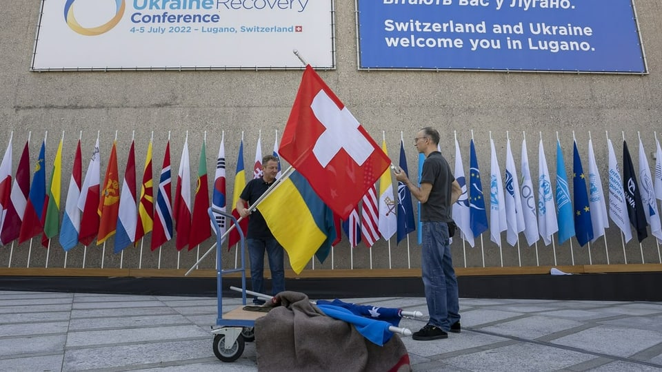 Männer hängen Flaggen auf in Lugano