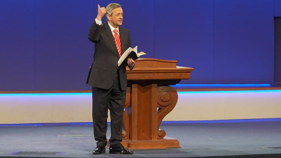 Pfarrer Robert Jeffress mit Bibel neben dem Rednerpult