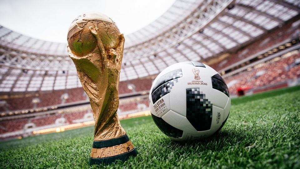 Der offizielle WM-Fussball von Adidas neben dem WM-Pokal.