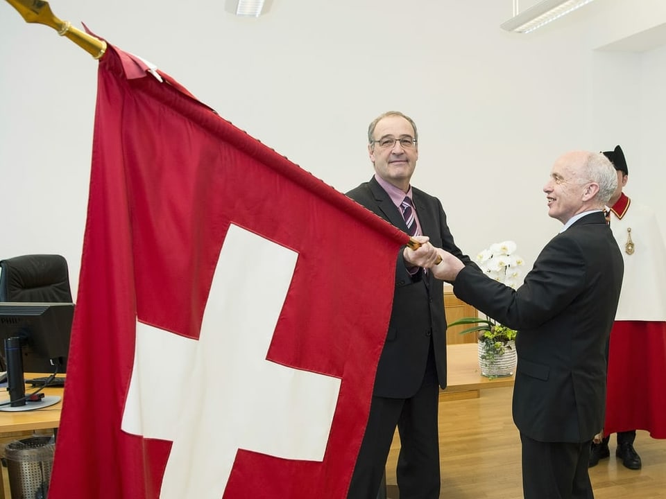 Ueli Maurer übergibt im Dezember 2015 seinem Nachfolger als Verteidigungs- und Sportminister Guy Parmelin symbolisch die Schweizer Fahne.