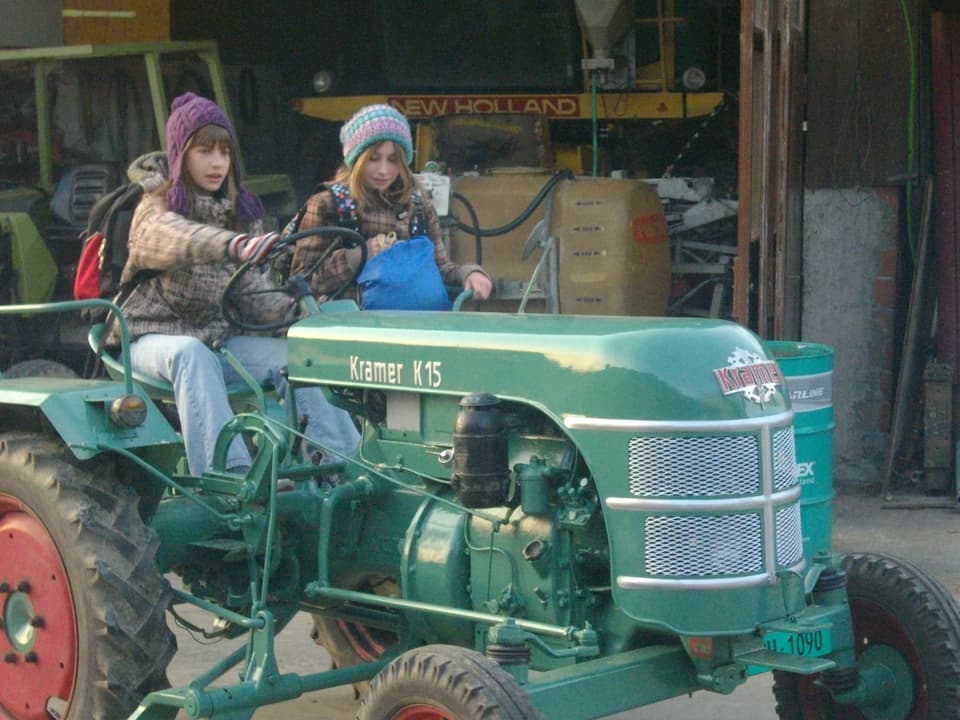 Zwei Mädchen auf einem Traktor.