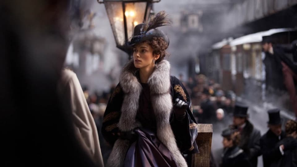 Anna Karenina, gespielt von Keira Knightely, steht am Gleis auf einem Bahnhof.