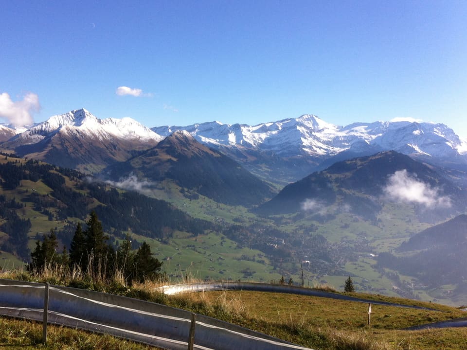 Alpenpanorama, die Gipfel sind frisch verschneit. Darüber blauer Himmel.