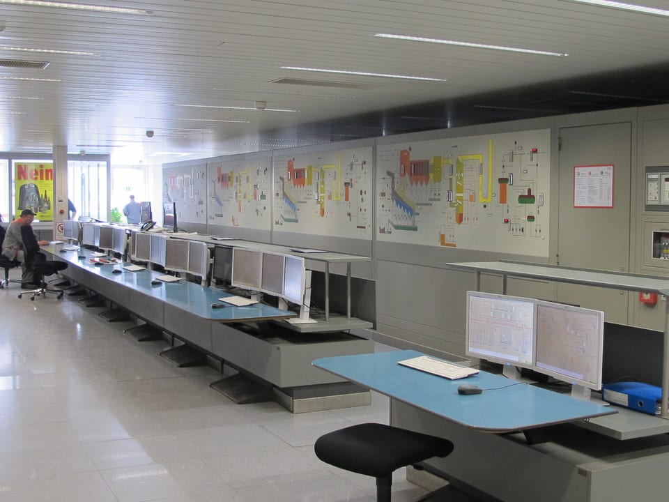 Ein Kontrollzentrum mit mehreren Tischen und einer Anzeigetafel