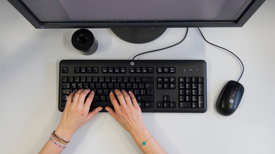 Frauenhände an einer Computertastatur