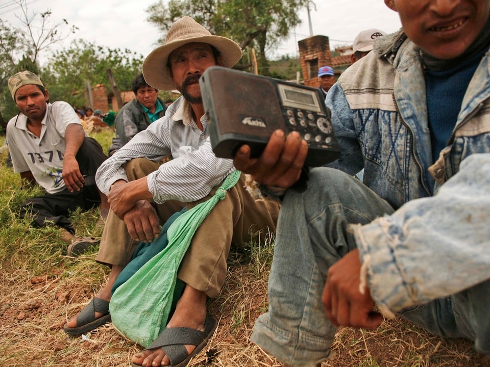 Südamerikanische Landarbeiter hören Radio.