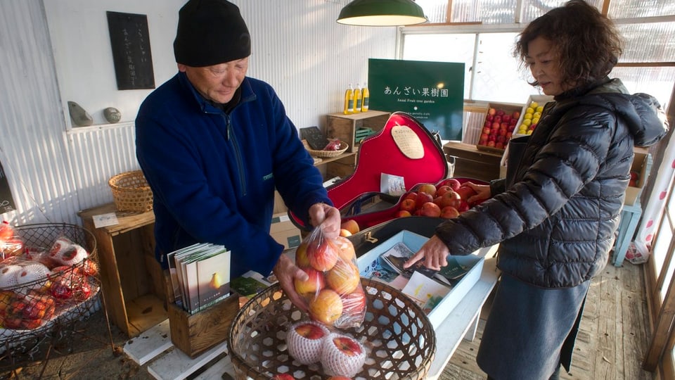Ein Obstbauer verkauft seine Äpfel an der berühmten Obststrasse von Fukushima. 