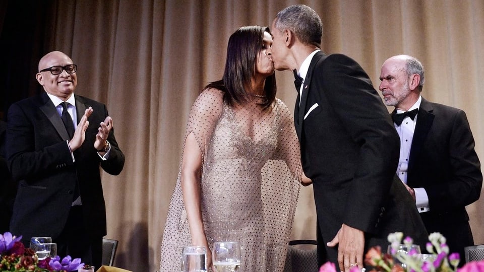 Barack Obama küsst seine Frau Michelle. 