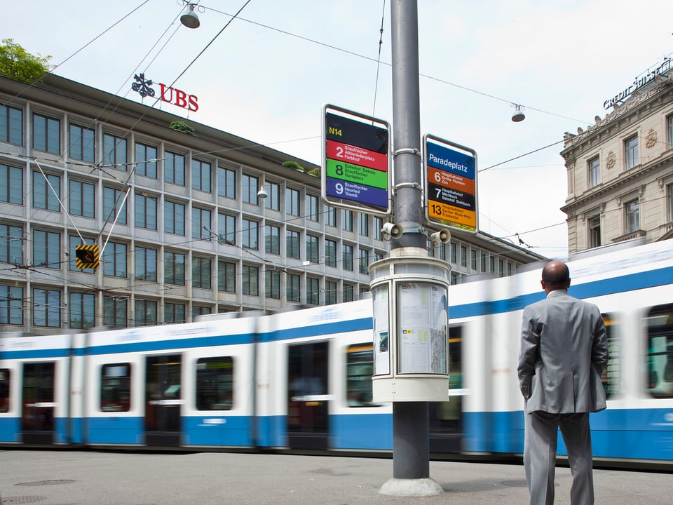 Mann steht an der Tramstation am Paradeplatz in Zürich.