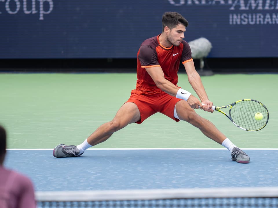 Tennis player in red outfit hitting the ball