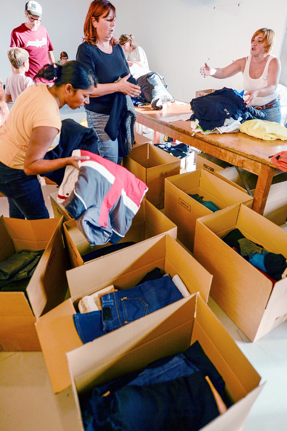 Freiwillige der privaten Hilfsaktion «Tsueri hilft» beim Aussortieren von Kleidern. 