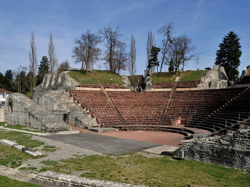 Man sieht das halbrunde römische Theater mit Bäumen im Hintergrund. 