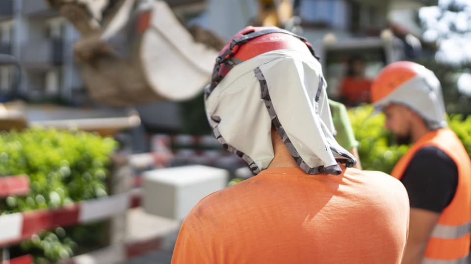 Bauarbeiter schützen sich mit Helm und Nackentuch vor Sonne