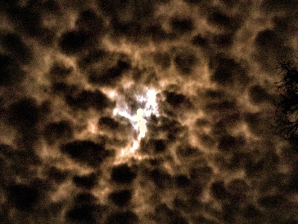 Schäfchenwolken am Nachthimmel mit Mond.