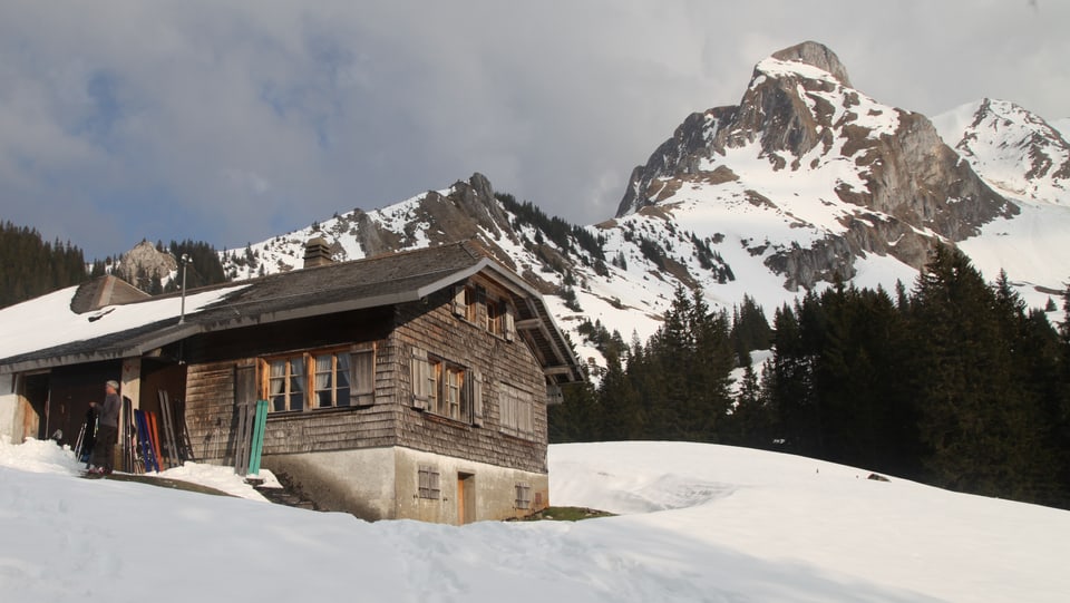 Obere Gantrischhütte mit Gipfel im Hintergrund. 